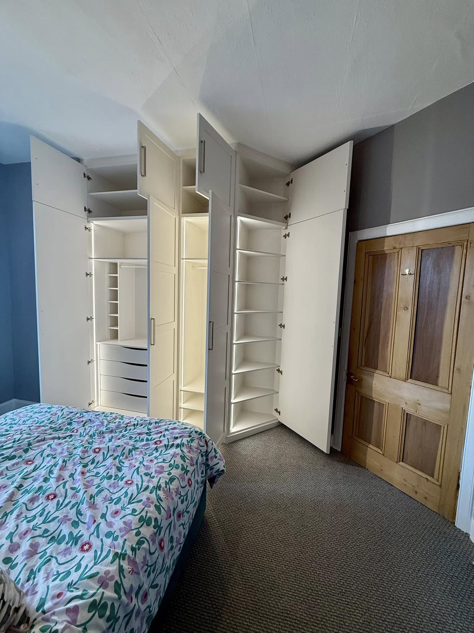 Bespoke wardrobe in Edinburgh bedroom with custom shelving and sliding doors by SJC Joinery (Scot) Ltd lighting