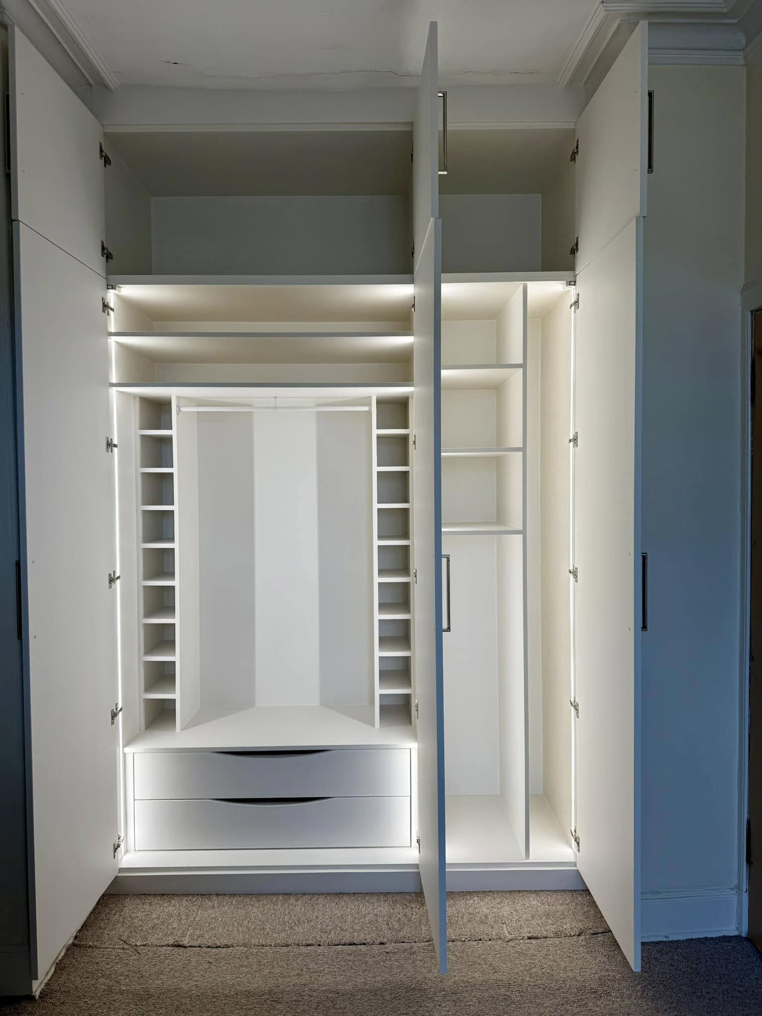Bespoke wardrobe in Edinburgh bedroom with custom shelving and sliding doors by SJC Joinery (Scot) Ltd lighting