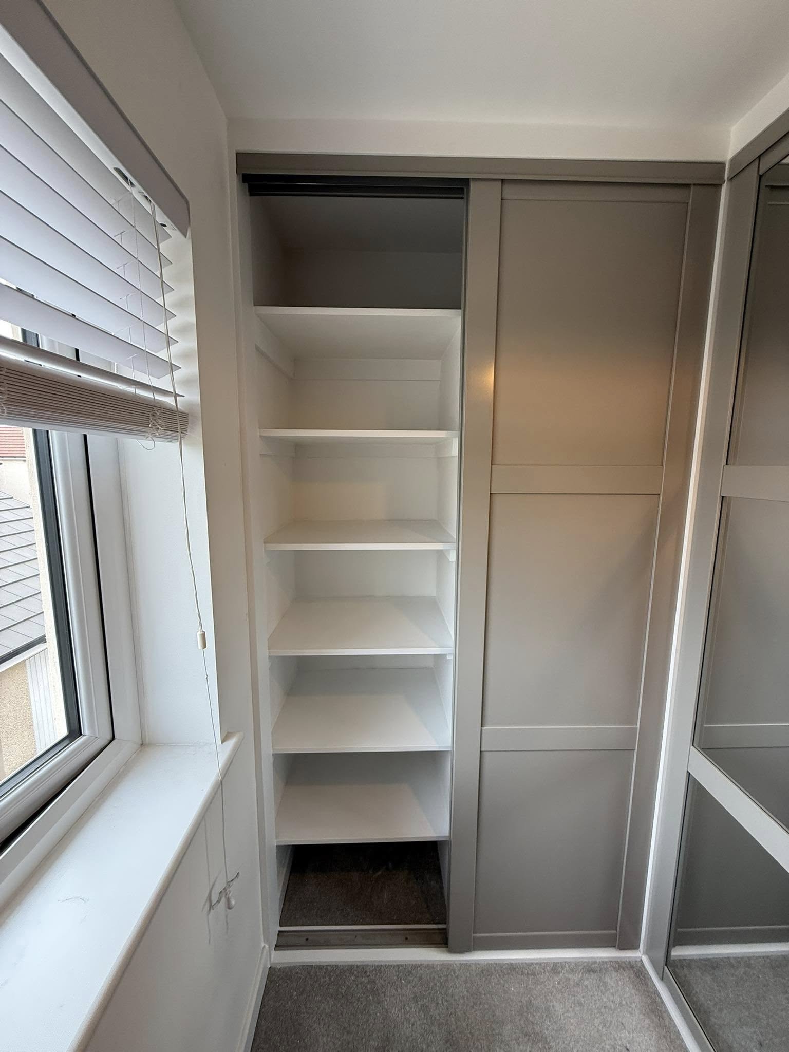 Bespoke wardrobe in Edinburgh bedroom with custom shelving and sliding doors by SJC Joinery (Scot) Ltd