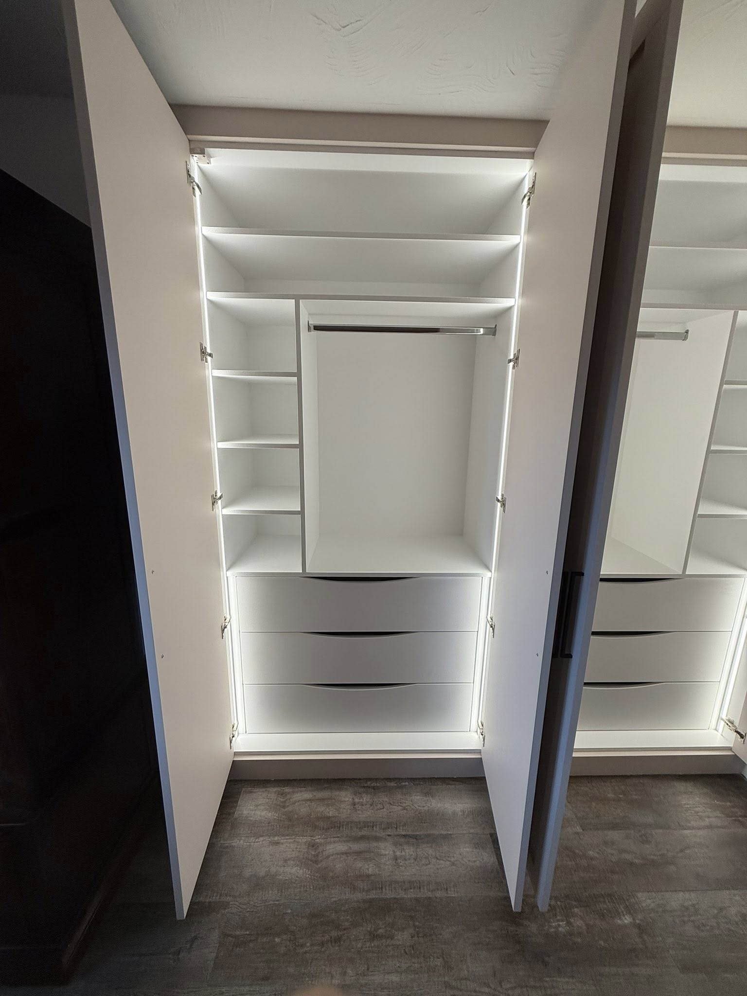 Tailored bedroom wardrobe in Edinburgh with organized shelves and hanging space lighting
